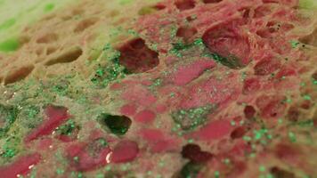 a close up of a piece of bread with green and pink paint video