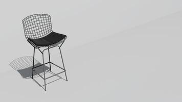 A white chair with a black cushion sits on a white wall photo