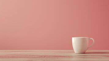 Coffee cup on wooden table in front of pink background. photo