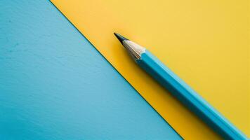 Blue pencil on a yellow and blue background. Minimalism. photo