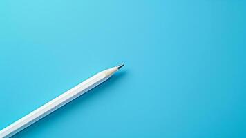 White pencil isolated on blue background with copy space for your text. photo