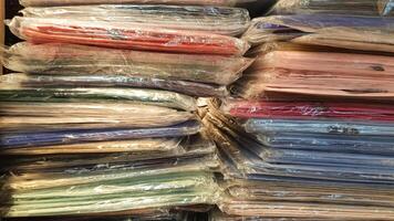 A pile of colorful clothes wrapped in plastic. Pattern A pile of clothes on a table in the background. A pile of colorful clothes wrapped in plastic photo