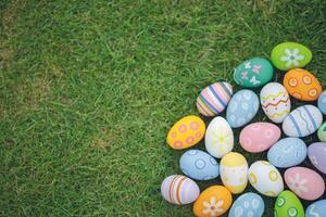 Collection of colorful easter eggs on green grass to celebrate Easter or spring. photo