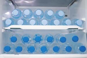 frío Bebiendo agua en el refrigerador foto