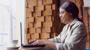 Smiling young indian woman blogger influencer sit in cafe speaking looking at camera talking make conference call record lifestyle blog concept video