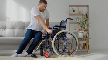 Disabled man having difficulty getting into a wheelchair from sofa video