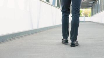 Rear back view feet of businessman commuting to work. Cityscape background video