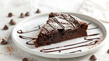 a piece of brownie cake with melted chocolate on a white plate on a white background photo