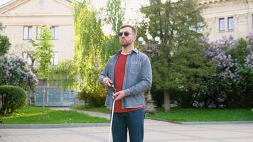 Blind man setting up walking cane in park. Independence concept video