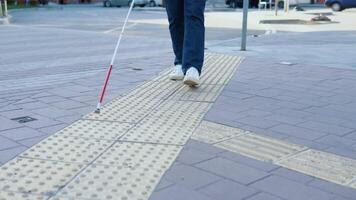 ben av blind person sökande särskild taktil plattor använder sig av sockerrör. blind man gående med en sockerrör i de gata video