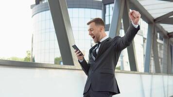 uma feliz barbudo comece Homem de negócios lendo Boa notícia dentro Smartphone. social rede. pessoas video