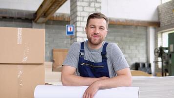 een professioneel arbeider in uniform met een groot rollen van papier in een het drukken magazijn video