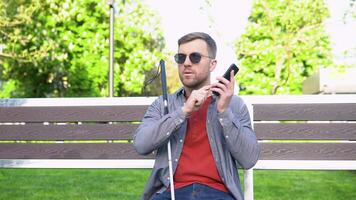 ciego hombre con invalidez utilizando digital asistente y facilitar de acceso funciones en teléfono inteligente video