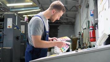 grafico progettista la scelta colori a partire dal colore tavolozza. concetto di colore gestione nel il Stampa produzione processi. Catalogare campioni per stampa prove video