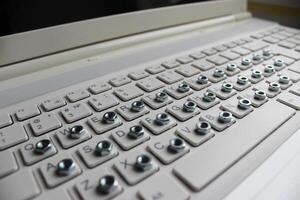 Angled side view of a computer keyboard with an iron nut on each button photo