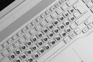 Metal nuts overlap symbols on a white computer keyboard top view stock photo