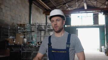 Professional worker walking through logistics center warehouse factory. Construction site logistics architect man builder indoors video