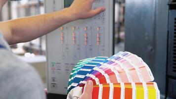 Grafik Designer wählen Farben von Farbe Palette. Konzept von Farbe Verwaltung im das drucken Produktion Verfahren. Katalog Proben zum Drucken Proofing video