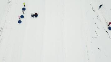 gens balade sur neige tube. neige tube station balnéaire. aérien vue video