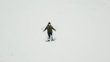 pequeño chico es tendido en el nieve. aéreo video