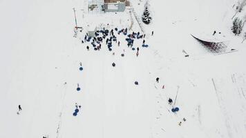 mensen rijden Aan sneeuw buis. sneeuw buis toevlucht. antenne visie video