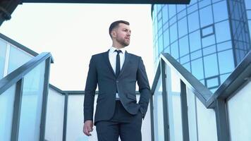 Confident guy in leather shoes and suit being on his way to office building. Businessman in suit being on his way to work. Cityscape background video