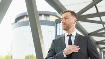 A well dressed happy bearded office corporate male executive standing outside a modern corporate building video