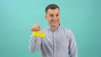 uma feliz positivo caucasiano homem dentro uma azul camisa alegremente monitores uma brinquedo compras cesta dentro dele mãos video