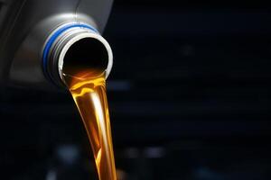 Pour engine oil from the lubricant bottle. Engine background, oil change shop engine service industry photo