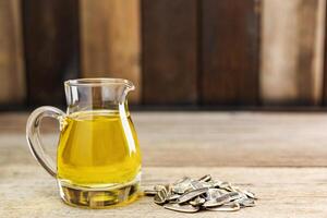 Sunflower oil and sunflower seeds On a traditional rustic wooden floor Concept of organic food and environment Healthy food and fat photo