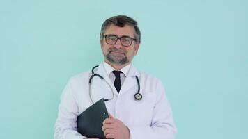 portret van een senior dokter in wit pak met stethoscoop en registratie logboek video