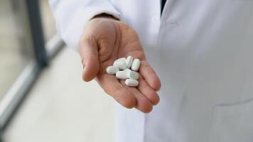 Senior doctor holds pills in hand. Close up view of hands video