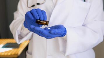 Senior female doctor in white coat takes pills out of a jar. Close up view of hands video