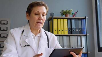 Sénior femelle médecin faire en ligne appel consulter patient. caucasien femme thérapeute conférence parlant à caméra dans éloigné bavarder video