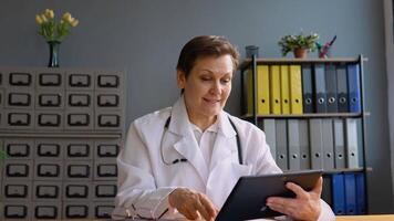 Senior female doctor make online call consult patient video