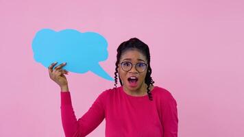 africano americano menina dentro Rosa roupas carrinhos com cartazes para expressão em uma sólido Rosa fundo. uma Lugar, colocar para publicidade slogans video