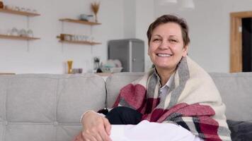 portret van een senior vrouw zittend Aan een sofa video