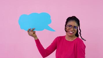 Jeune africain américain fille dans rose vêtements des stands avec affiches pour expression sur une solide rose Contexte. une endroit pour La publicité slogans video