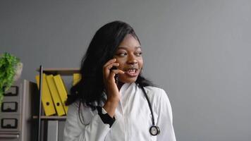 Young african woman doctor consultpatient by phone video
