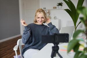 retrato de joven mujer, estilo de vida bloguero, grabación vlog acerca de su vida y diario rutina, sentado en frente de computadora portátil, hablando a seguidores, sentado en su habitación foto
