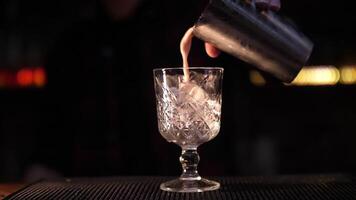 fabbricazione un alcolizzato cocktail. il barista versa un' cocktail. cocktail nel un' bicchiere. video