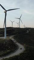 verticaal video van jeeps het rijden moutain weg windmolens