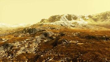 A snow-covered mountain range with a contrasting backdrop of brown grass video