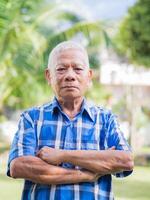 Senior man with crossed hands wears a blue shir photo