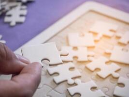 Close-up of hands woman's holding connecting jigsaw puzzle with sunlight effect. Space for text photo