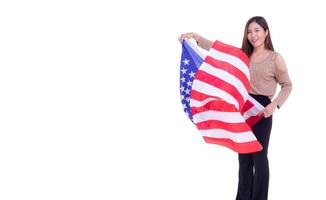 Young woman holding the American flag, smiling and looking at the camera with a white background while standing in the studio. Space for Text photo