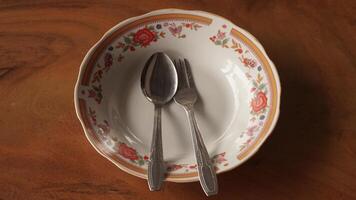 a spoon and fork are on a plate with a floral pattern photo
