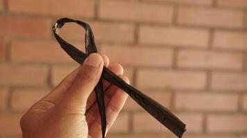 photo of someone's hand holding a raffia rope in the form of a ribbon