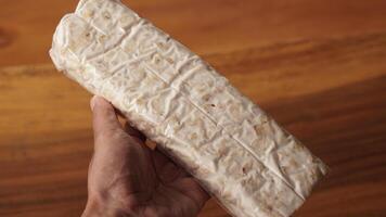traditional Indonesian food called tempeh. photo of hand holding tempeh in raw form