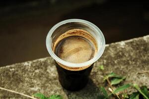 negro café servido en un el plastico taza a comienzo el día. foto